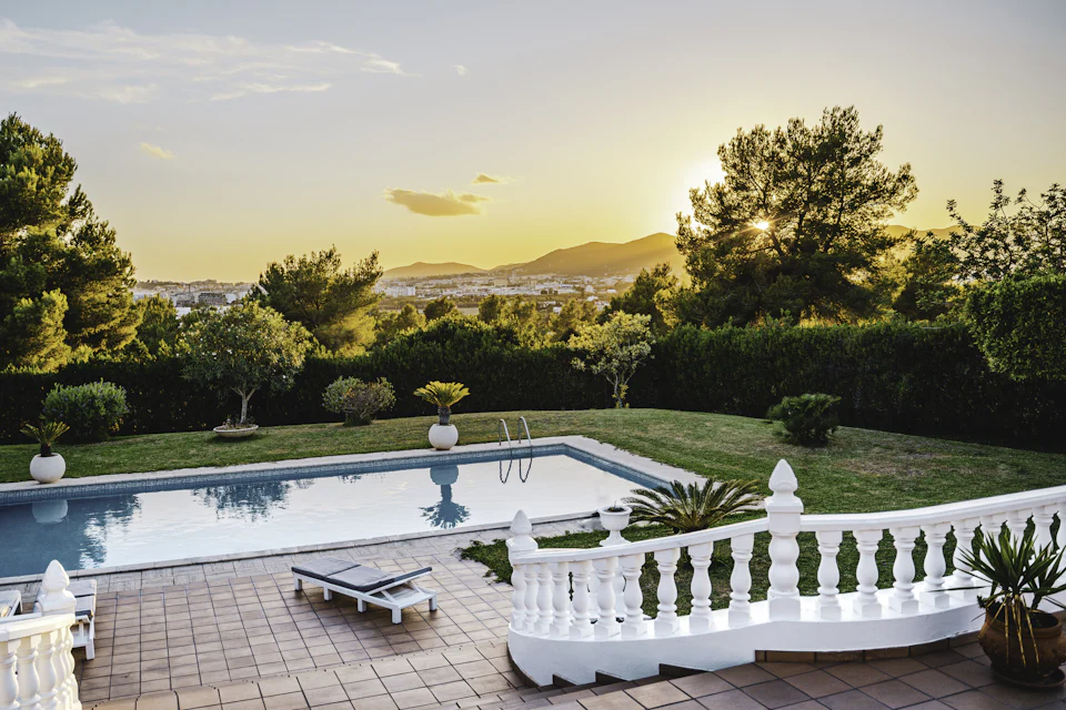 Garten mit Pool und Hügeln im Abendlicht
